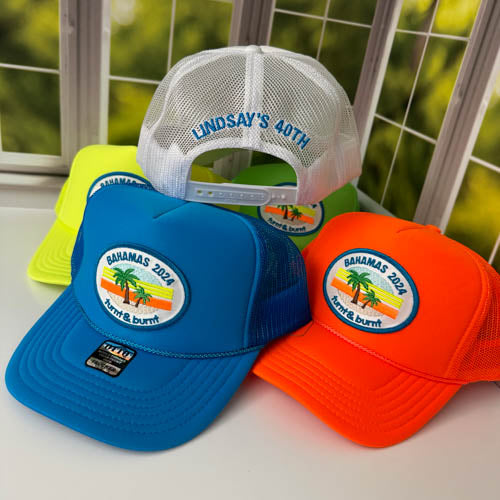 Turquoise, neon orange and neon yellow trucker hats with palm tree patch, white hat with back embroidery